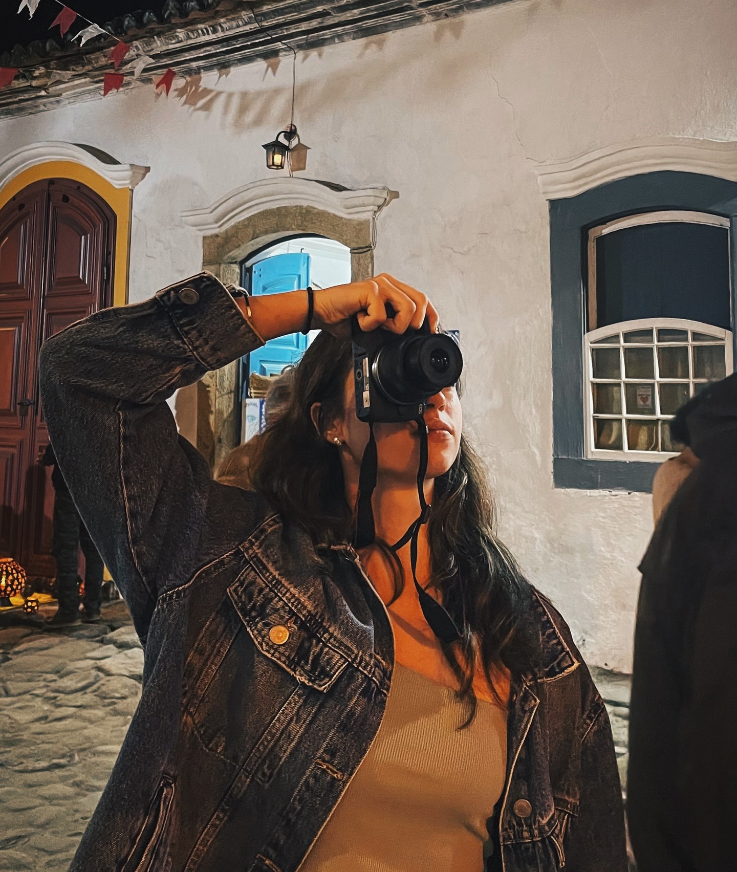 Maria Helena fotografando com uma câmera